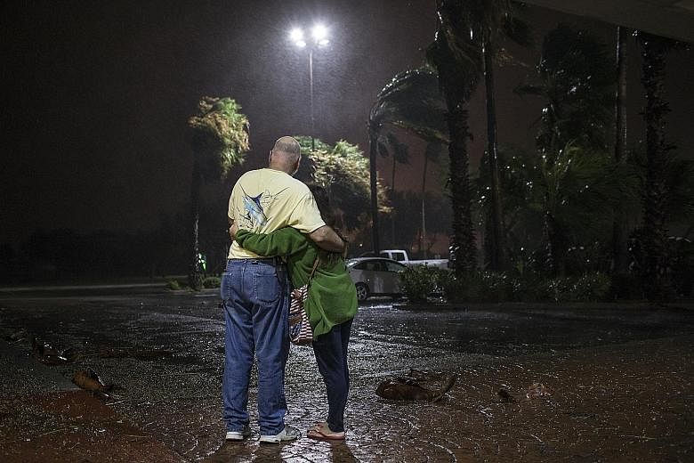 A couple who were evacuated from Aransas Pass, Texas, looking out at the heavy rain from a hotel in Corpus Christi, Texas, last Friday.