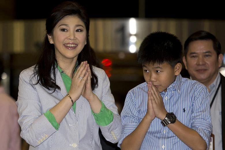 Yingluck Shinawatra and son Supasek Amornchat at Suvarnabhumi Airport in 2014. The former premier left her only child in the care of her businessman husband last week before leaving the country, said a source.