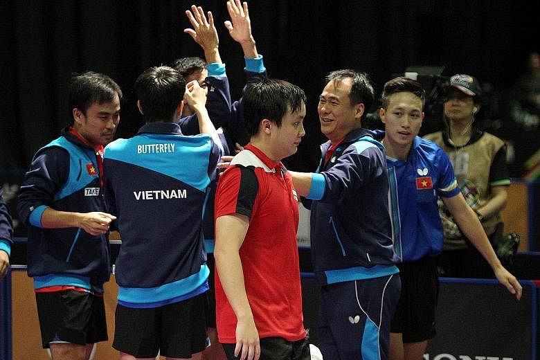 A crestfallen Pang Xue Jie walking away as the Vietnamese men rejoice in their 3-1 upset win over Singapore in the team final.