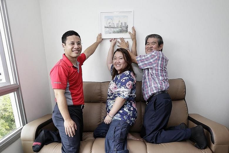 Member of Parliament Desmond Lee (left), home owner Esther Tan and artist Ong Kim Seng, with the print Ms Tan received.