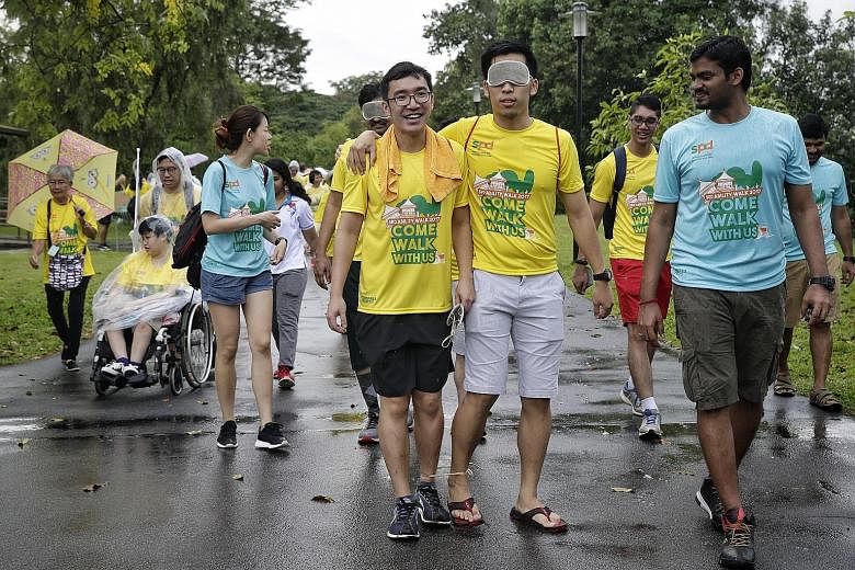 A participant trying out an obstacle challenge by walking 200m both blindfolded and three-legged at the Chinese Garden yesterday during the 3km SPD Ability Walk, now in its second year. One participant found walking blindfolded "scary".