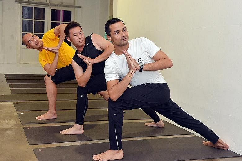 Mr Dev Kapil, director of One Wellness Fitness Club, and two of his male yoga students (from left) Andy Teo, 48, and Alex Lau, 43. Mr Dev attributes the increase in male yoga enrolment to research done over the years that has raised awareness about i