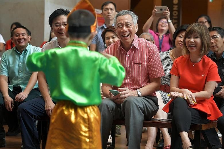 Above: Kindergarten children performing at the PCF Family Day held at the National Gallery Singapore yesterday. Below: Prime Minister Lee Hsien Loong, with National Development Minister Lawrence Wong and Senior Minister of State for the Environment a