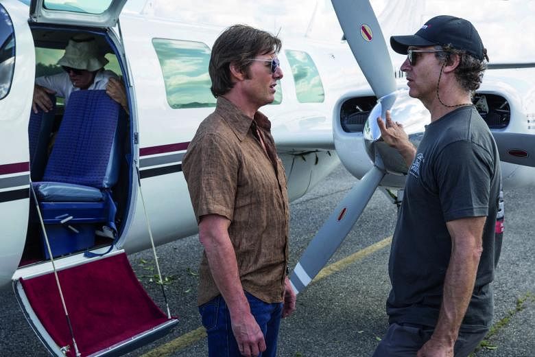 Director Doug Liman with Tom Cruise (far left) on the set of American Made.