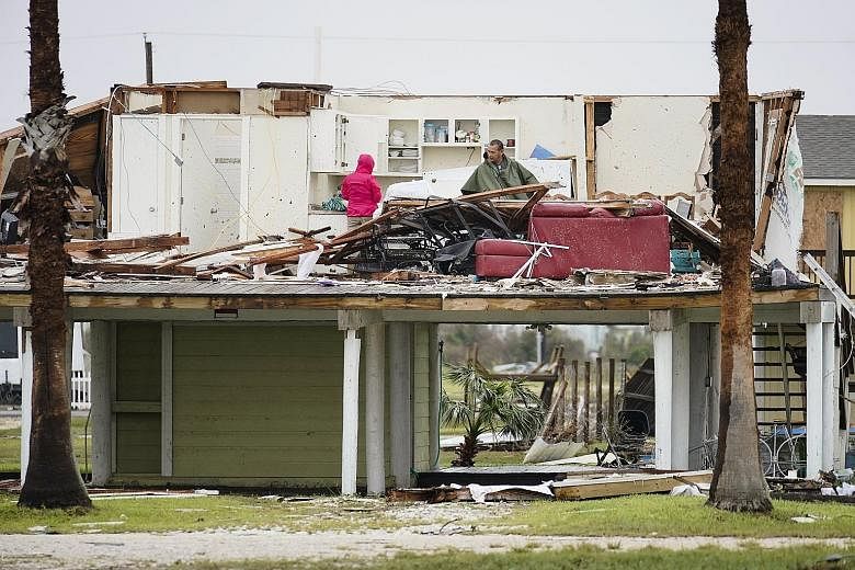 Rockport residents working to clean up their house in the aftermath of the storm on Monday. The floods could destroy up to $27 billion in insured property, analysts say. People being rescued from a flooded neighbourhood in Houston after it was inunda