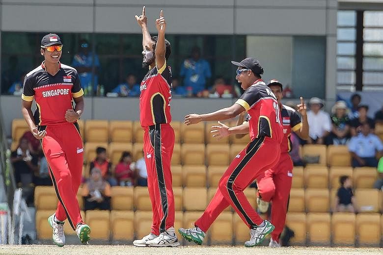 Singapore right-arm bowler Shoib Razak (left) celebrates after dismissing a Malaysian batsman in the T20 final.