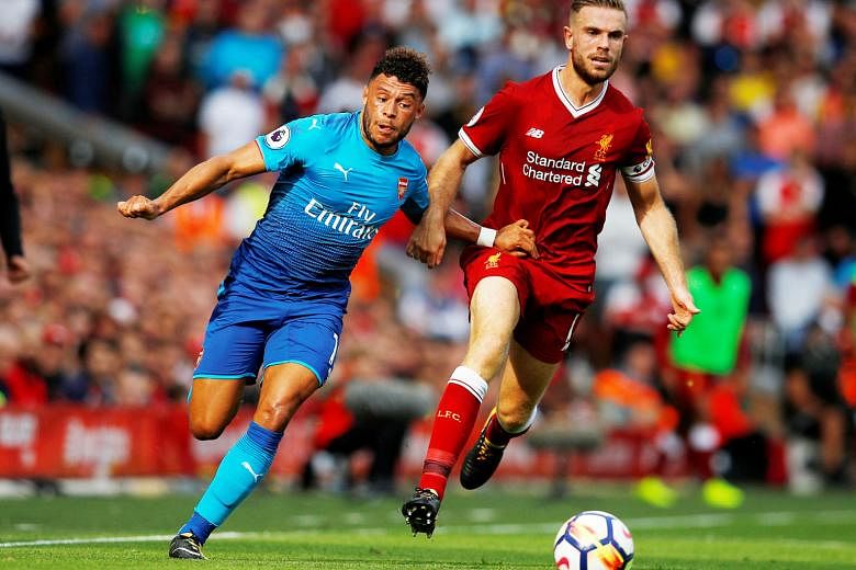 Arsenal's Alex Oxlade-Chamberlain playing as a right wing-back at Anfield as he challenges Liverpool captain Jordan Henderson for the ball. The 24-year-old England international can also play anywhere in midfield.