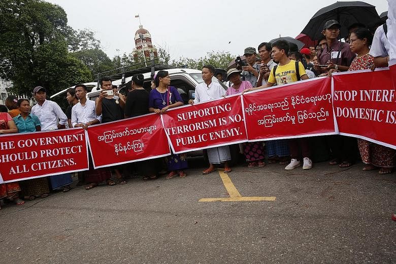 Myanmar nationalists during a rally yesterday in Yangon against former United Nations chief Kofi Annan's commission report and the recent attacks reportedly carried out by the Arakan Rohingya Salvation Army in the country's northern state of Rakhine.