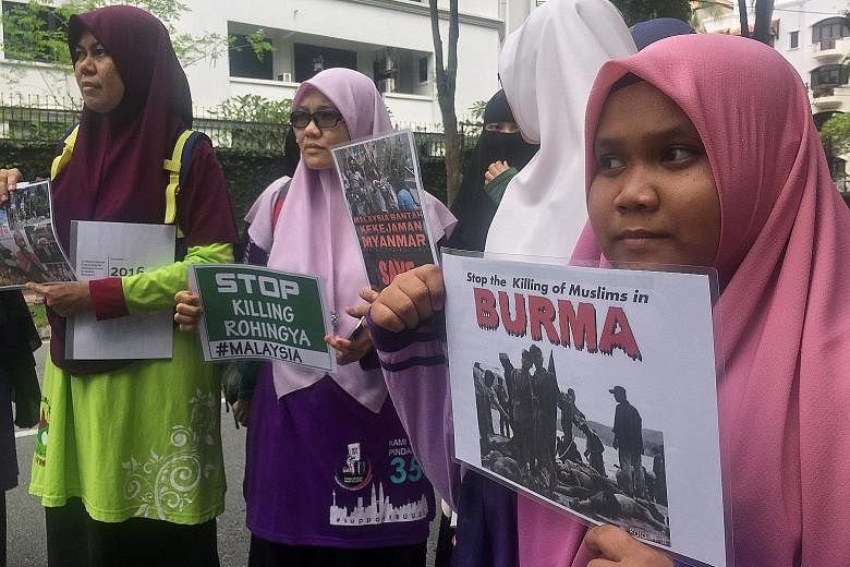 Protesters holding placards near the Myanmar embassy in Kuala Lumpur yesterday. They demanded that Myanmar stop the violence against the minority Rohingya community. 