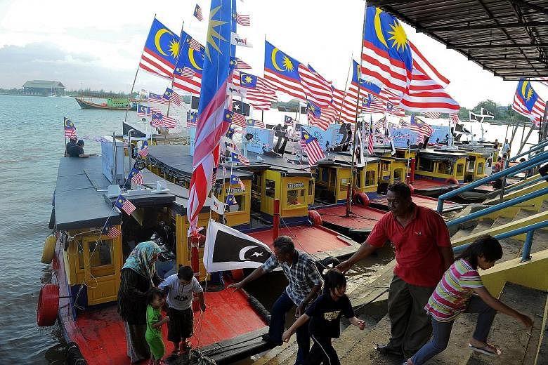 Terengganu state ferries bedecked with Malaysian flags, ahead of the country's national day, at the Seberang Takir jetty. The ferries had participated in a 16-boat event earlier to sail along Sungai Terengganu.