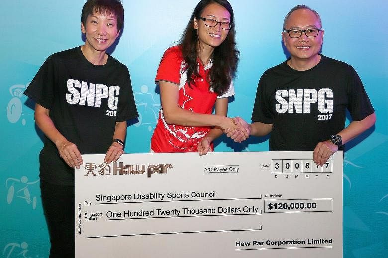 Kelly Fan, Singapore Disability Sports Council executive director (centre), receiving the $120,000 sponsorship cheque from Tarn Sien Hao, group general manager of Haw Par. With them is Ms Grace Fu, Minister for Culture, Community and Youth.