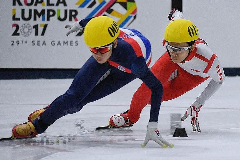 Ice skater Lucas Ng (right) in action during the men's 1,000m speed skating final yesterday. He bagged two silvers at the Games, despite suffering from a serious injury that resulted in his right hand being taped up.