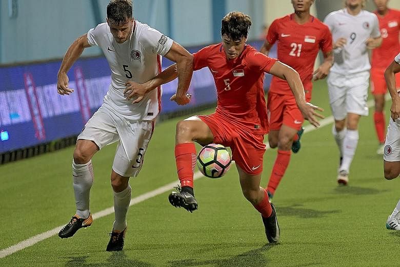 Singapore debutant Ikhsan Fandi (right) keeps the ball as Hong Kong defender Helio Goncalves closes him down. The 18-year-old was a second-half substitute and drew praise from Lions coach V. Sundram Moorthy.