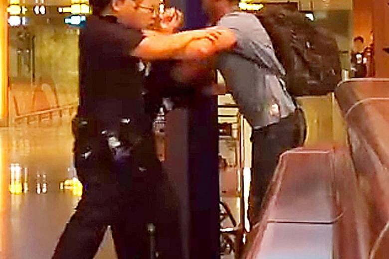 A screenshot from a video showing Jason Peter Darragh, 44, tussling with police at Changi Airport Terminal 2 on April 20.