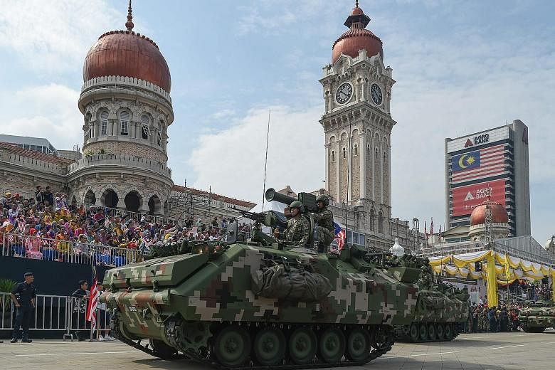 Armoured vehicles rumbling down Kuala Lumpur's Merdeka Square at yesterday's 60th National Day celebrations.