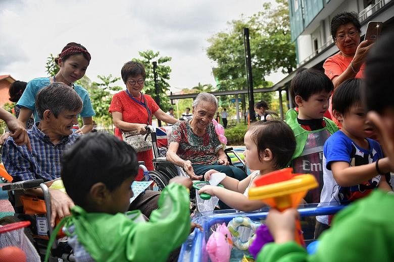Nursing home residents and children interact under supervision at the inter- generational playground of St Joseph's Home.