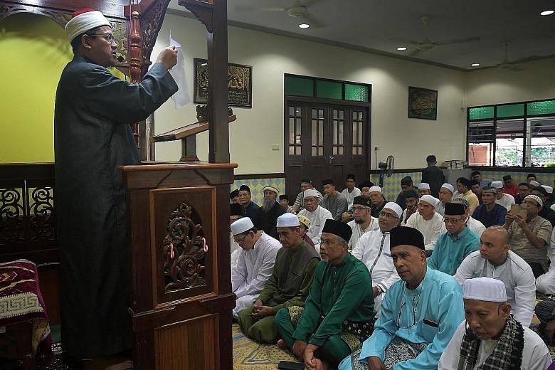 Mufti Mohamed Fatris Bakaram leading morning prayers at Masjid Petempatan Melayu yesterday. Among the congregants attending was Minister Masagos Zulkifli (front row, third from right).
