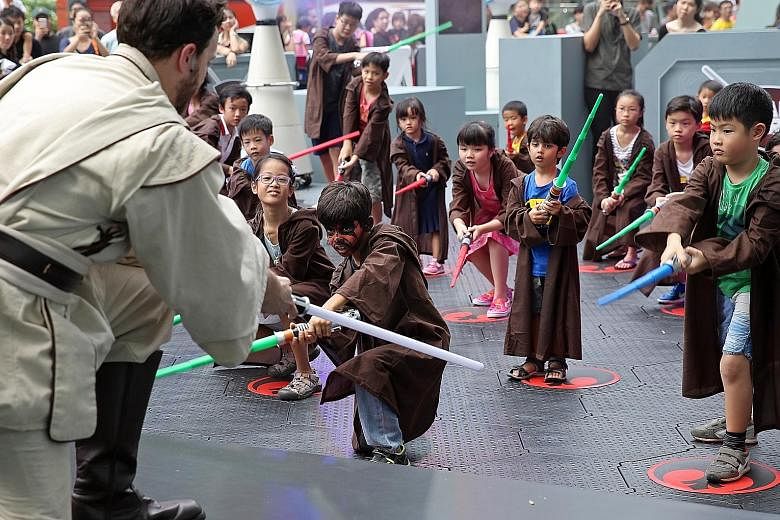 Vihaan Chopra (with painted face) and younger brother Vinayak (in blue T-shirt) in a Padawan "training" session held at the Star Wars: Experience The Force festival outside ION Orchard shopping mall yesterday.
