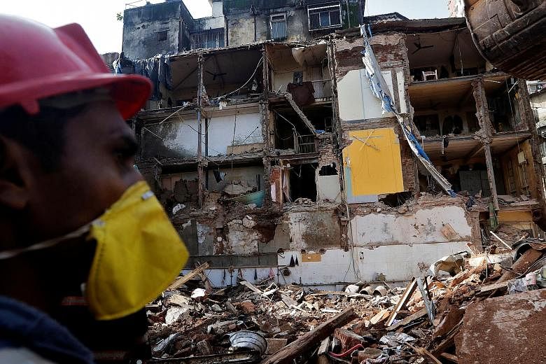 A rescue worker searching for survivors yesterday at the site of the building collapse in Mumbai. The 117-year-old building came crashing down on Thursday after days of heavy rain.