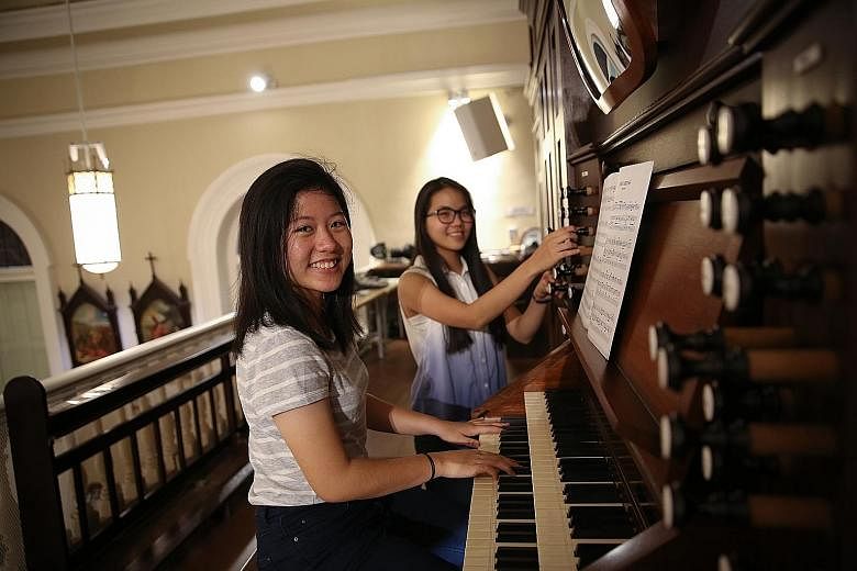 Ms Nadine Wong (left) and Ms Anne Maria Lim, two of six candidates in the Cathedral Organ Scholar Programme, at the organ of the Cathedral of the Good Shepherd. Scholars "graduate" when they can play at mass without assistance.