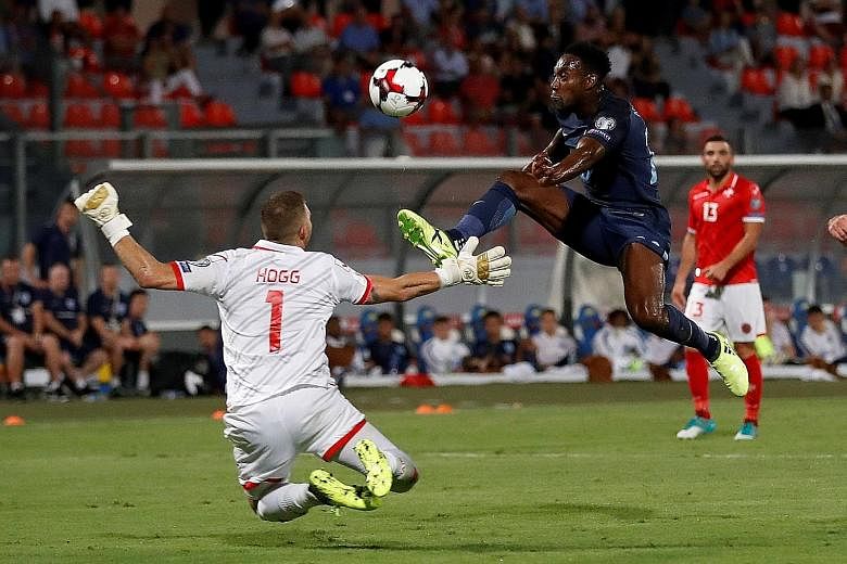 England's Danny Welbeck lifting the ball over Malta goalkeeper Andrew Hogg in stoppage time for his side's third goal. The late flurry of goals added gloss to the 4-0 scoreline which was not as one-sided as it appeared, with three England goals comin