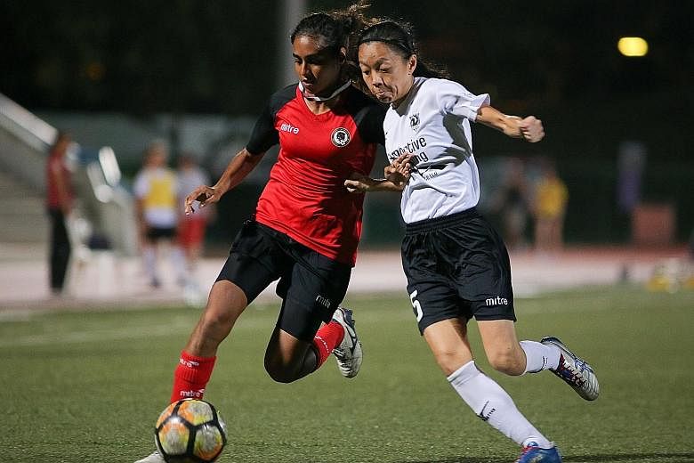 Suria Priya of leaders Tanjong Pagar United (left) attempting to keep possession, as Arion Football Academy's Sharon Tan put her under pressure in their FAS Women's Premier League match at Serangoon Stadium yesterday. The game ended 1-1.