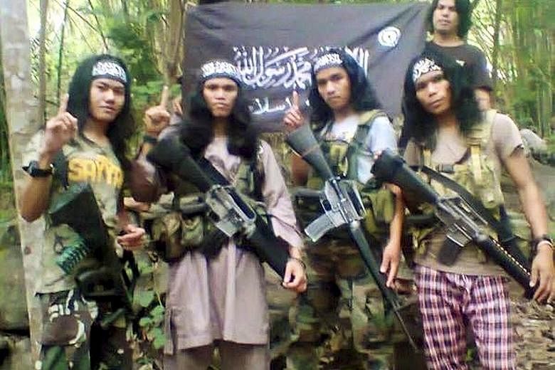 Hajar Abdul Mubin (extreme left) - otherwise known as Abu Asrie - in an undated photo taken in the southern Philippines. Hajar, a Filipino, was arrested along with one other Filipino and six Malaysians from the Borneo state of Sabah in a raid last We
