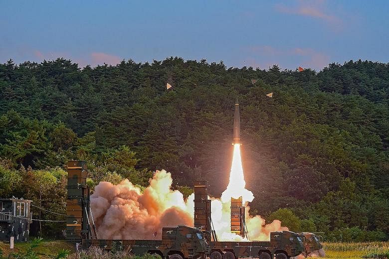 Left: A Hyunmoo-2 missile being launched at an undisclosed location on the east coast of South Korea yesterday during a live-firing exercise, after North Korea's sixth nuclear test a day earlier. A sign denoting a bomb shelter at a subway station in 
