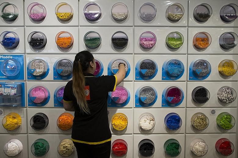 An employee in the Lego flagship store at Forum des Halles shopping centre, in central Paris. The Danish toymaker, known for its iconic coloured plastic bricks, said yesterday it would cut 1,400 jobs around the world before the end of the year. The c