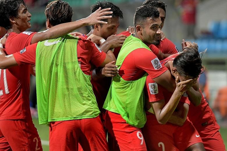 The Lions celebrating the game's opening goal by Shakir Hamzah (right) against Turkmenistan in the Asian Cup qualifier at Jalan Besar Stadium yesterday. The 1-1 draw means that Singapore remain at the bottom of Group E with two points after two draws