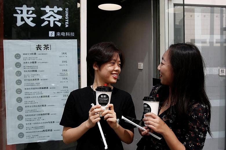 Customers with cups of tea named in the fashion of the "sang" subculture at the Sung Tea shop in Beijing last month. While the drink names are tongue-in-cheek - such as "achieved-absolutely-nothing black tea" and "my-ex's-life-is-better-than-mine fru