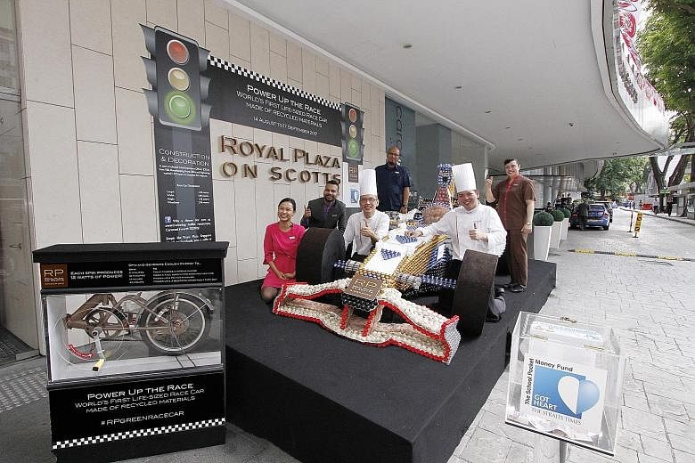 The Royal Plaza on Scotts team behind the life-size race car made from recycled materials. The hotel will match dollar for dollar donations placed in the box for The Straits Times School Pocket Money Fund.