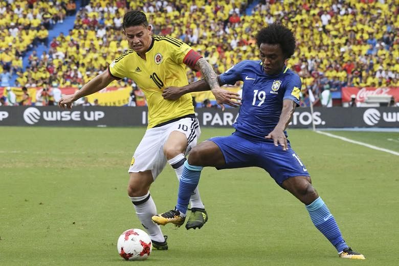 Colombia's James Rodriguez (left) and Brazil's Willian vie for the ball during the 1-1 draw in their World Cup qualifier on Tuesday. Willian volleyed home the game's opening goal in the first half.