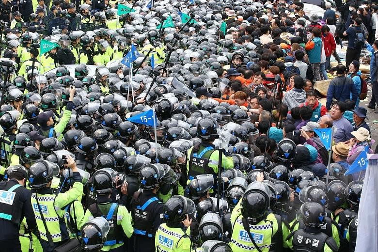 Riot police clashing with protesters who tried to block trucks carrying Thaad launchers in Seongju, South Korea, yesterday.