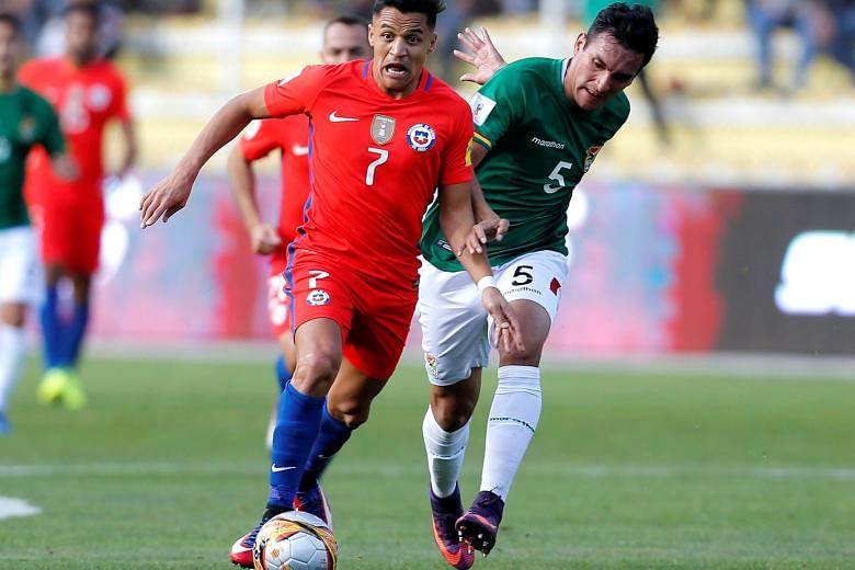 Alexis Sanchez goes past Bolivia defender Gabriel Valverde during Chile's 1-0 loss in the World Cup qualifier. The Arsenal star, whose move to Manchester City did not materialise, is not yet fully fit but Gunners manager Arsene Wenger expects him to 