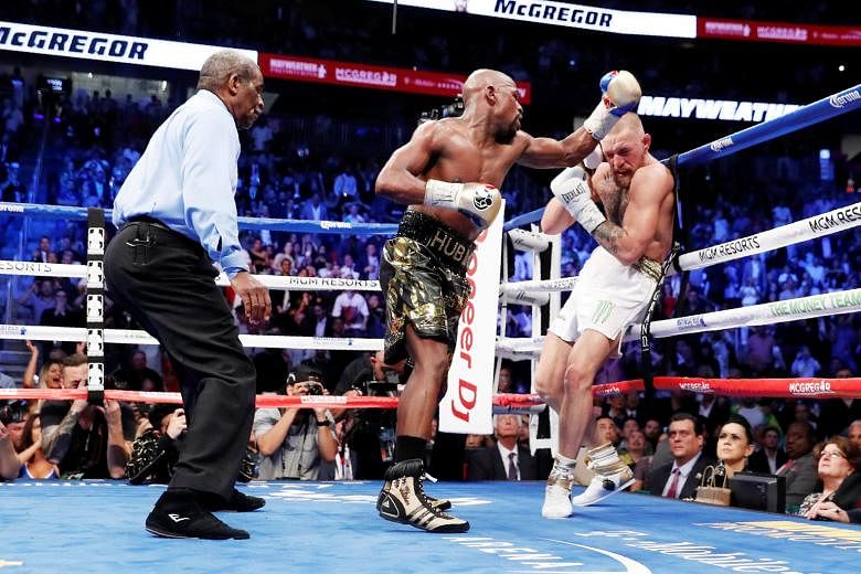 Floyd Mayweather has Conor McGregor on the ropes before winning their fight by a technical knockout in the 10th round. The victory gave the American a landmark 50-0 career record.