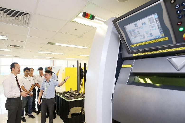 At A*Star's new Industrial Additive Manufacturing Facility yesterday, Dr Koh Poh Koon is shown a laser beam powder bed machine, which uses a laser beam to melt metal powder and turn it into 3D printing material. Technical components can then be produ