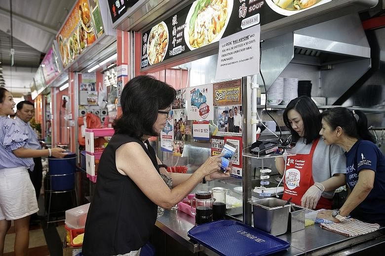 A patron scanning the QR code at Tanjong Pagar Plaza Market and Cooked Food Centre. Hawkers get a confirmation on their terminals - and receive payment the next working day.