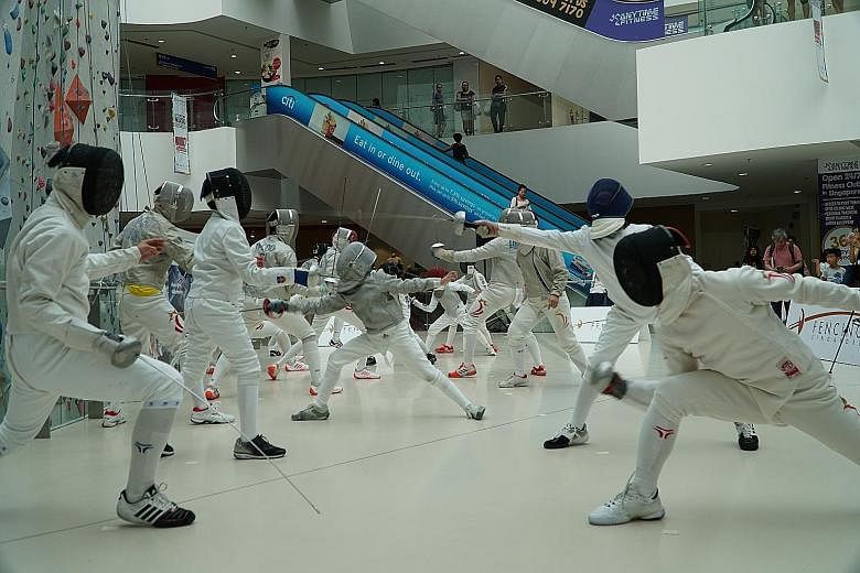 Fencers participating in a flash mob at Kallang Wave Mall yesterday in celebration of World Fencing Day. Earlier, SEA Games champion Lau Ywen and medallists Ahmad Huzaifah Saharudin and Jet Ng also spoke about their journey in the sport.