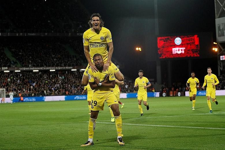 Kylian Mbappe (bottom) celebrates scoring Paris Saint-Germain's second goal with Edinson Cavani. Cavani netted twice as PSG trounced Metz 5-1.