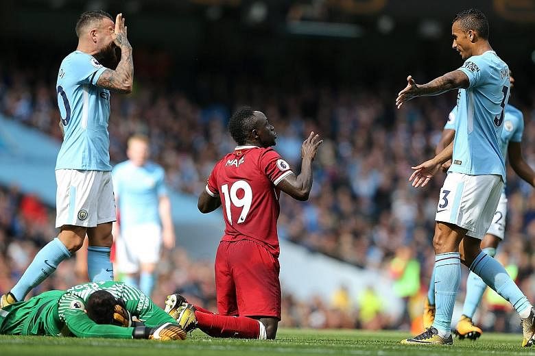 Manchester City's goalkeeper Ederson on the ground after being fouled by Liverpool forward Sadio Mane, resulting in a red card for the Senegal international.