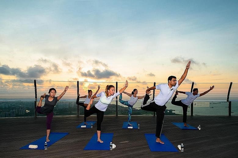 Romanian tennis professional Simona Halep (centre) taking part in a morning yoga session at Marina Bay Sands during a promotional tour of the WTA Finals in 2015.