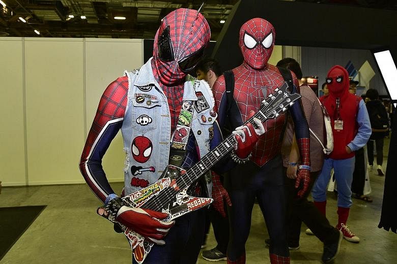 Cosplayers came dressed as, among other characters, Spider-Men (above) and Harley Quinn; while other attendees crossed lightsabers for a wefie.