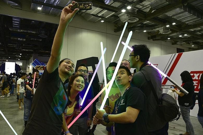 Cosplayers came dressed as, among other characters, Spider-Men and Harley Quinn; while other attendees crossed lightsabers for a wefie (above).