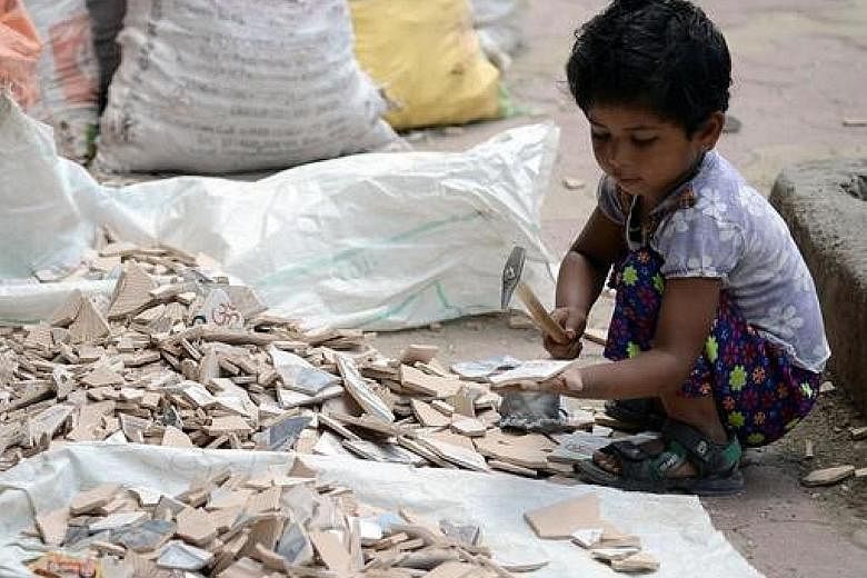 A child breaking tiles outside a construction site in Mumbai in 2015. Nobel Peace Prize winner Kailash Satyarthi and his team raid mills, mines and factories to rescue children from bonded labour.
