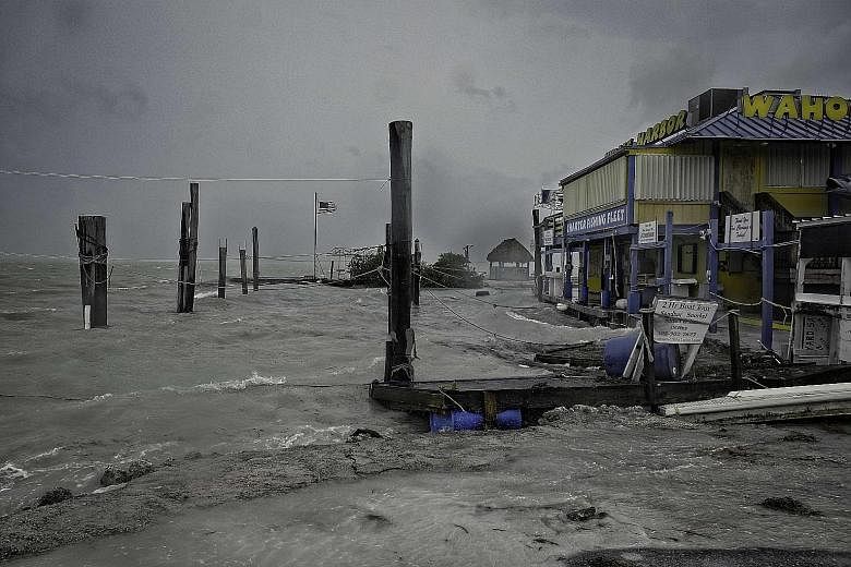 The docks of the Florida Keys (left) being battered by rough surf churned up by the approaching Irma on Saturday while Florida residents took refuge in shelters like this one at a school in Tampa. A scene after the passage of Hurricane Irma in the Cu