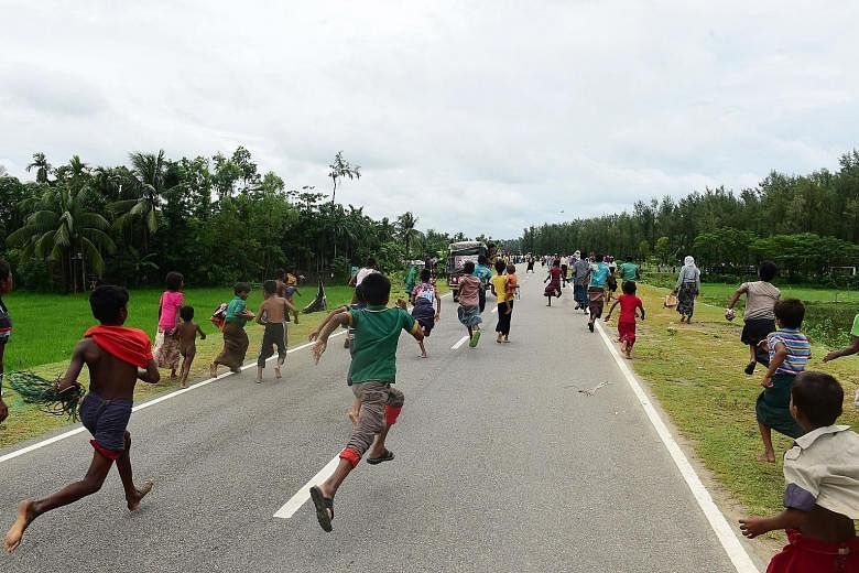 The children of Rohingya refugees running after a vehicle carrying relief supplies near the Bangladeshi town of Teknaf yesterday. The UN said the wave of hungry and traumatised refugees fleeing Myanmar's northern Rakhine state is "showing no signs of