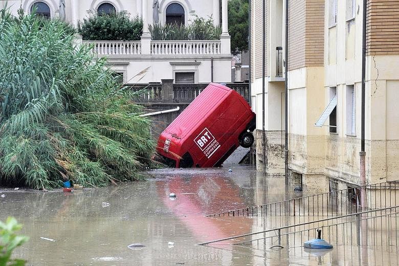 A van stuck in a flooded street in Livorno, Italy, yesterday. Fire services said the city took the brunt of the flooding.