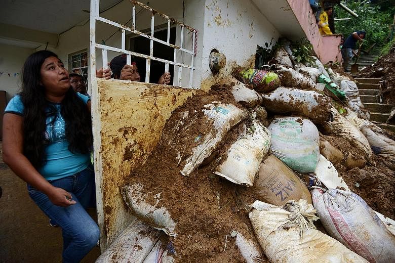 Residents in a neighbourhood struck by mudslides that were set off by heavy rains after storm Katia swept through Xalapa city in Veracruz last Saturday. Two major catastrophes just days apart have left Mexico reeling from the punch.