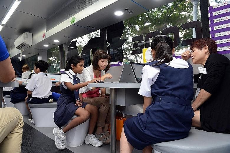 Pupils helping participants at an intergenerational IT boot camp in 2015. Dr Janil Puthucheary said that to help the elderly in the digital journey, Singapore will consider user-friendly e-payment solutions, including wearables.